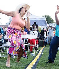 Friends Jarene Fleming (left) and Cristal Jones (right) dance during the steel orchestra’s performance.