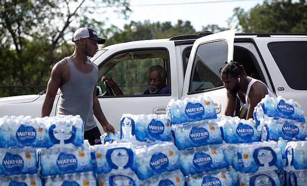 Quad Johnson, left, and Island Williams carry water to a vehicle at a water distribution center at Grove Park Community Center in Jackson, Mississippi, on August 31.
Mandatory Credit: Austin Steele/CNN
