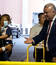 Manuel Castro greets migrants exiting a bus from Texas at the Port Authority on August 30. Castro himself crossed the US-Mexico border with his mother when he was 5.
Mandatory Credit:	Yuki Iwamura/Bloomberg/Getty Images