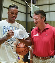 Mr. Bacot, a senior at the University of North Carolina, signs a ball for Gov. Glenn Youngkin, who also played basketball in college.