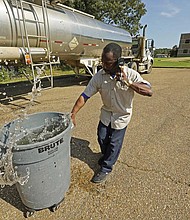 Santonia Matthews, a custodian at Forest Hill High School in Jackson, Miss., hauls away a trash can filled with water from a tanker in the school’s parking lot on Aug. 31. The tanker is one of two placed strategically in the city to provide residents non-potable water. The recent flood worsened Jackson’s long-standing water system problems and the state Health Department has had Mississippi’s capital city under a boil-water notice since late July.