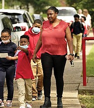 Spann Elementary School principal Lori G. Torrey, below, leads a group of children to their parent’s cars following a full day of in-school learning after having to again undertake virtual learning classes due to the city’s water issues that forced Jackson Public Schools to close for several days.