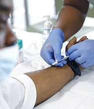 David Hightower, 57, left, looks away while receiving the monkeypox vaccine by registered nurse Jeremy Oyague, right, with The Los Angeles Department of Public Health at a vaccination clinic to immunize people against monkeypox and COVID.
Mandatory Credit:	Christina House/Los Angeles Times/Getty Images