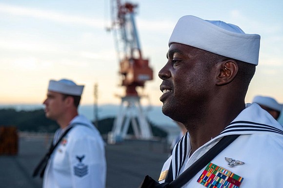 Aviation Boatswain’s Mate (Handling) 1st Class Nicholas Ochieng, from Rosenberg, Texas, a Chief select, stands in formation for evening colors …