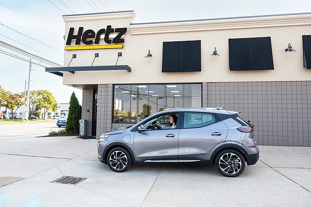 A woman drives a Gray Ghost Metallic 2023 Chevrolet Bolt EUV in front of a Hertz rental location in Michigan. Hertz will begin taking deliveries of the Chevrolet Bolt EV and Bolt EUV in the first quarter of 2023.