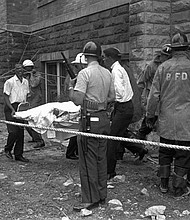 Firemen and ambulance attendants remove a covered body from the 16th Street Baptist Church, where an explosion ripped the structure during services, killing four black girls, on Sept. 15, 1963. Sarah Collins Rudolph lost an eye and has pieces of glass inside her body from a Ku Klux Klan bombing that killed her sister and three other young girls inside an Alabama church 59 years ago.