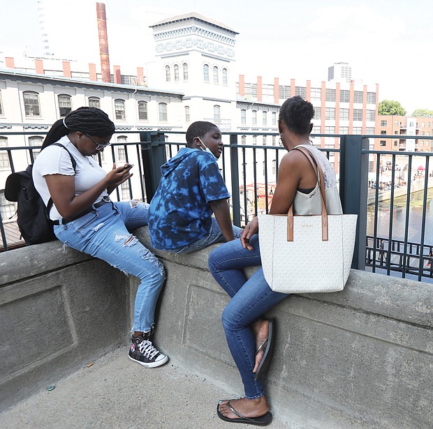 Shiloh Duncan, 7, of Richmond, center, found the perfect place Sunday to enjoy the RVA Street Art Festival with his sister, left, Jaisah Duncan, 15, and their mother, Melissa Duncan. The family, perched at The Power Plant Building along the Haxall Canal in Downtown Richmond, also got a closer look at the muralists working during the festival’s 10th anniversary. For Shiloh, the spot and art were perfect. “So cool ... We can see the people, the water and the artwork.”