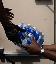 Members of Progressive Morningstar Baptist Church move cases of water after a Sunday morning service in Jackson, Mississippi
