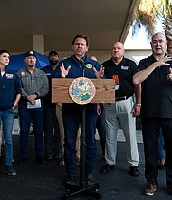 Just weeks after Ron DeSantis, center, seen here on October 4 in Cape Coral Florida, made a very public display of his efforts to keep migrants from coming to Florida, Hurricane Ian's destruction is drawing a growing number of immigrants to the state.
Mandatory Credit:	Joe Raedle/Getty Images