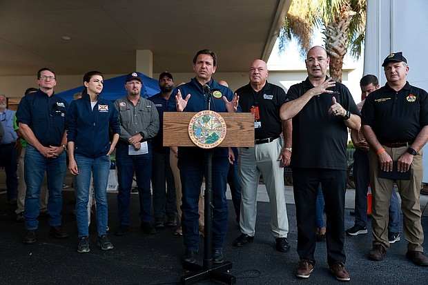 Just weeks after Ron DeSantis, center, seen here on October 4 in Cape Coral Florida, made a very public display of his efforts to keep migrants from coming to Florida, Hurricane Ian's destruction is drawing a growing number of immigrants to the state.
Mandatory Credit:	Joe Raedle/Getty Images