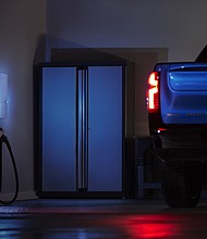 A 2024 Chevrolet Silverado RST in a residential home garage equipped with Ultium Home offerings. Show truck shown. Actual production model will vary. Model year 2024 Silverado EV expected to be available fall 2023