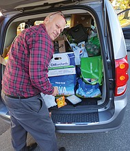 Joseph E. “Joey” Matthews, who began lending a helping hand three years ago and today responds to calls from a volunteer network of 20 to 30 people, unloads goods to distribute to Southwood Apartments residents.