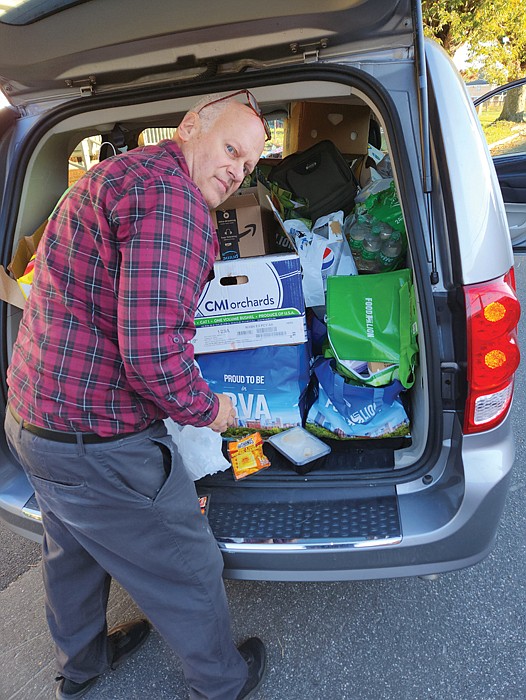 Joseph E. “Joey” Matthews, who began lending a helping hand three years ago and today responds to calls from a volunteer network of 20 to 30 people, unloads goods to distribute to Southwood Apartments residents.