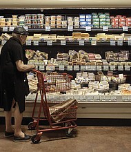 A shopper is shown at a supermarket in New York. On Thursday, Oct. 13, the U.S. government will announce what’s virtually certain to be the largest increase in Social Security benefits in 40 years. The boost is meant to allow beneficiaries to keep up with inflation, and plenty of controversy surrounds the move.