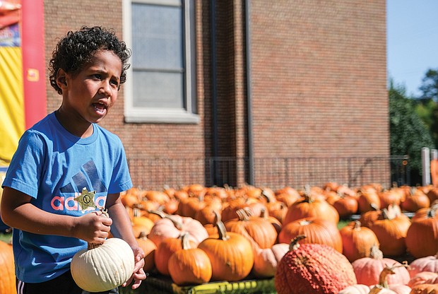 Elliott Mosby is careful not to drop his pumpkin at Ginter Park United Methodist Church on West Laburnum Avenue in the city’s North Side. Elliott visited the church’s pumpkin patch with his mother, Danielle Heerchap, on Oct. 15.