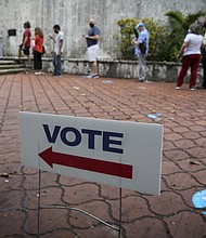 A Florida judge on Friday dismissed the case against a Miami man who was arrested on charges related to election fraud in August. A "Vote" sign is displayed in Miami on October 19, 2020.
Mandatory Credit:	Marco Bello/Bloomberg/Getty Images