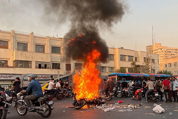People gather next to a burning motorcycle in the capital Tehran on October 8.
Mandatory Credit:	Stringer/AFP/Getty Images