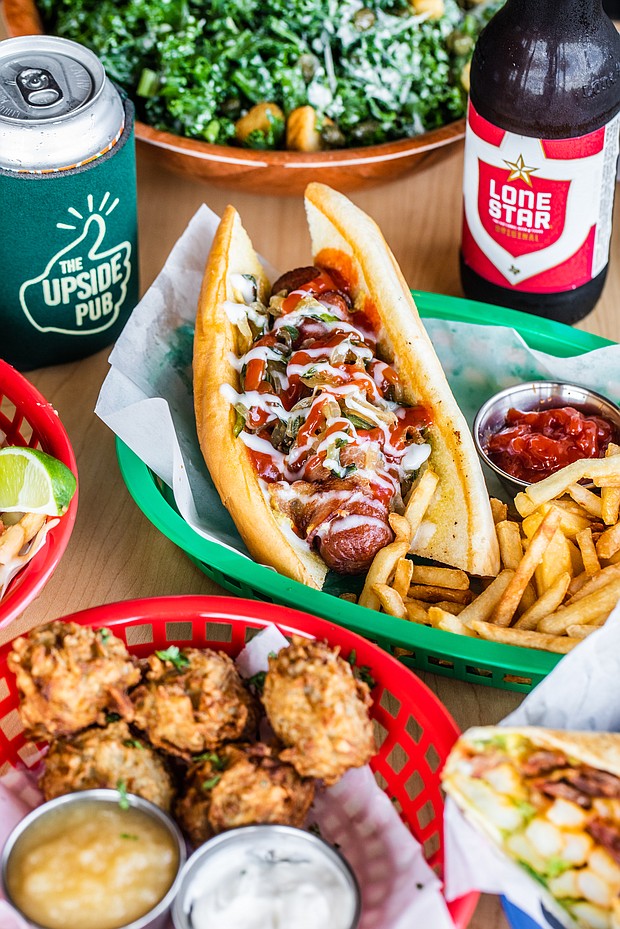 The Brisket Hot Dog is wrapped in bacon with caramelized onions and peppers, pickled jalapeños, mustard, ketchup and mayonnaise. (Photo by Becca Wright)