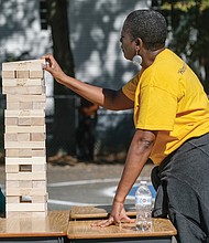 First-grader Luz Luna plays a game of Jenga with first-grade teacher Carla Lewis during the Barack Obama Elementary School Centennial Celebration and Fall Extravaganza at the North Side school on Oct. 22.