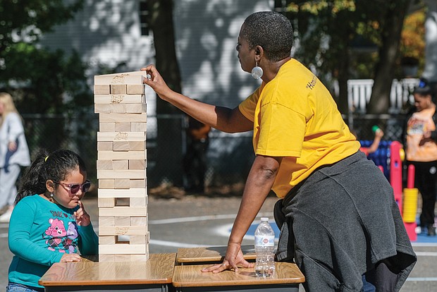 First-grader Luz Luna plays a game of Jenga with first-grade teacher Carla Lewis during the Barack Obama Elementary School Centennial Celebration and Fall Extravaganza at the North Side school on Oct. 22.