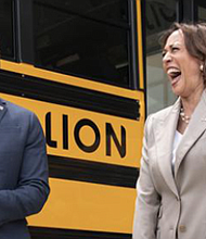 Vice President Kamala Harris, right, laughs with Environmental Protection Agency Administrator Michael Regan, during a tour of electric school buses in May 2022 at Meridian High School in Falls Church.