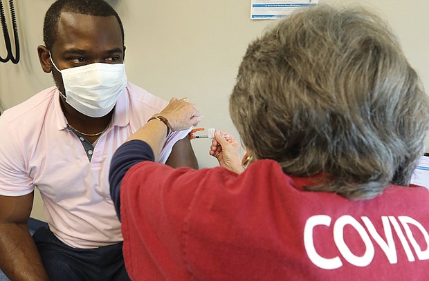 Richmond Mayor Levar Stoney receives his COVID-19 booster shot and flu shot on Oct. 13 to show that both shots can safely be administered the same day.