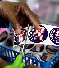 A poll worker prepares "I voted" stickers for voters at the City Clerk's Office ahead of the midterm election in Lansing, Michigan, on November 7.
Mandatory Credit:	Evelyn Hockstein/Reuters