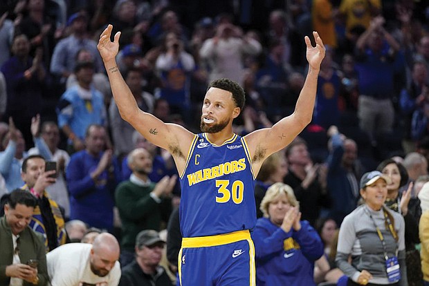 Golden State Warriors guard Stephen Curry (30) celebrates Monday after shooting a 3-point basket against the Sacramento Kings during the second half of an NBA basketball game in San Francisco.