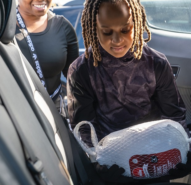 Wearing a thoughtful smile on her face, Richmonder Mekhi Anthony, 10, was among volunteers on Nov. 12 who assisted residents during the 5th Annual Thanksgiving Turkey Give-Away at the South Side Community Center on 6255 Warwick Road. This project was sponsored by 9th District City Councilman Michael J. Jones.