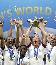 Megan Rapinoe lifts up the trophy and celebrates with teammates after winning the Women’s World Cup final soccer match in July 2019 between the United States and The Netherlands at the Stade de Lyon in Decines, outside Lyon, France.