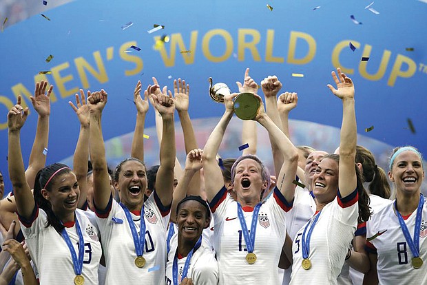 Megan Rapinoe lifts up the trophy and celebrates with teammates after winning the Women’s World Cup final soccer match in July 2019 between the United States and The Netherlands at the Stade de Lyon in Decines, outside Lyon, France.