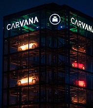 Signage outside a Carvana Vending Machine location in Novi, Michigan, is seen here in October 2021. Used-car retailer Carvana Co. is cutting 1,500 jobs, or 8% of its workforce.
Mandatory Credit:	Emily Elconin/Bloomberg/Getty Images