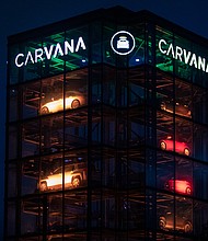 Signage outside a Carvana Vending Machine location in Novi, Michigan, is seen here in October 2021. Used-car retailer Carvana Co. is cutting 1,500 jobs, or 8% of its workforce.
Mandatory Credit:	Emily Elconin/Bloomberg/Getty Images