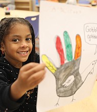 Henry L. Marsh III Elementary School first-grader Angelitha Suarez, 6, proudly displays her Fun Day art project on Tuesday, two days before Thanksgiving. Her turkey’s bright colors represent fall, she says.