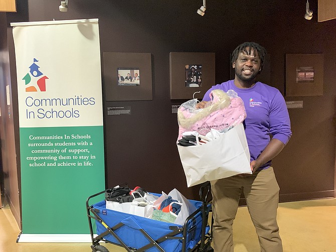 A Communities in Schools Volunteer helps a family carry out their items during a recent event at Lawndale Christian Health Center. PHOTO BY TIA CAROL JONES.