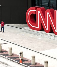 CNN begins layoffs in what CEO says will be a 'gut punch' to the network. People walk by the CNN headquarters on March 15, in Atlanta.
Mandatory Credit:	Anna Moneymaker/Getty Images