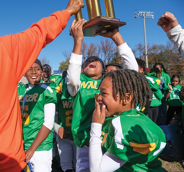 The RVA Trojans 10u football players representing Maggie Walker, celebrate their 6-0 win over the RVA Wildcats and Falcons, representing Armstrong in the Armstrong-Walker Legacy Classic Project football game.