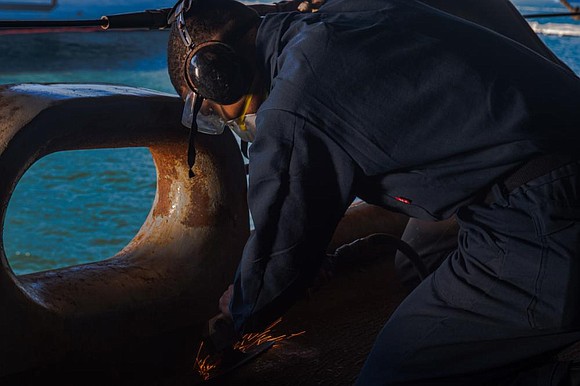 Seaman Allen Amarion, from Houston, sands the deck of the Nimitz-class aircraft carrier USS Harry S. Truman (CVN 75), November …