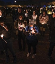 Community members, including Walmart employees, gather for a candlelight vigil at Chesapeake City Park in Chesapeake on Monday for the six people killed at a Walmart in the city, when a manager opened fire with a handgun before an employee meeting last week.
