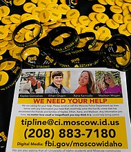 A flyer seeking information about the killings of four University of Idaho students is displayed on a table along with buttons and bracelets, Wednesday during a vigil in memory of the victims in Moscow, Idaho.
Mandatory Credit:	Ted S. Warren/AP