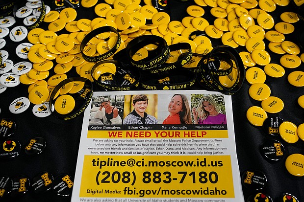 A flyer seeking information about the killings of four University of Idaho students is displayed on a table along with buttons and bracelets, Wednesday during a vigil in memory of the victims in Moscow, Idaho.
Mandatory Credit:	Ted S. Warren/AP