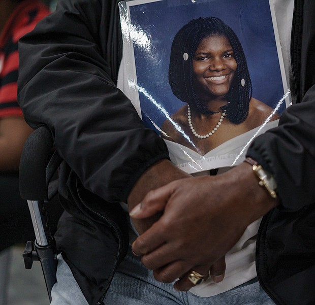 John Burnley holds a photo of his daughter, Juanita Burnley, who was shot and killed in 2007.