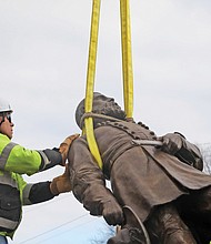 Team Henry Enterprises employees remove the A.P. Hill statue at the intersection of Hermitage and Laburnum on Monday. The statue of the fallen Civil War general was the last to stand on City property since the removal of other Confederate statues began in 2020.