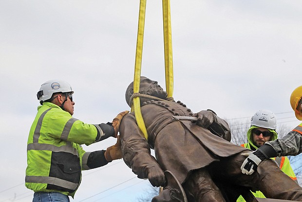 Team Henry Enterprises employees remove the A.P. Hill statue at the intersection of Hermitage and Laburnum on Monday. The statue of the fallen Civil War general was the last to stand on City property since the removal of other Confederate statues began in 2020.