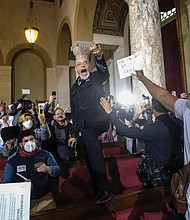 A small group of protesters chanted throughout the Dec. 13 Los Angeles City Council meeting, calling for the resignation of Councilman Kevin de Leon.