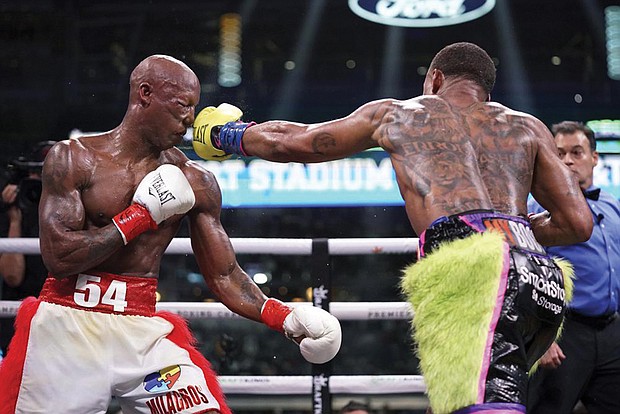 Errol Spence Jr., right, lands a punch on Yordenis Ugas, from Cuba, during a world welterweight championship boxing match Saturday, April 16, 2022, in Arlington, Texas.