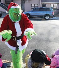 The Grinch who Stole Christmas appears to be in a good mood and the youngsters of the Friends Association for Children in Gilpin Court are just as excited to wave to him Tuesday during their annual Holiday Vehicle Parade. Other parade participants included the Victory 7 Mustang Club, Richmond Police Department, members of Richmond City Council and School Board and the Richmond Public Schools Lit Limo, who had Santa waving from a bus window.