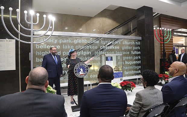 Rabbi Scott Nagel, left, and Cantor Sarah Beck-Berman of Congregation Beth Ahabah participate for the second year in the lighting of the City of Richmond’s menorah in the lobby of City Hall on the second evening of Hanukkah, Monday, Dec. 19. Mayor Levar M. Stoney, seated second from left, Richmond City Council President Cynthia Newbille, and 9th District City Council member Michael J. Jones listened as synagogue leaders performed celebratory songs.
