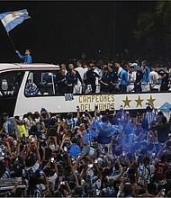 Argentina soccer fans crowd a highway for a homecoming parade for the players who won the World Cup title, in Buenos Aires, Argentina, Tuesday, Dec. 20,