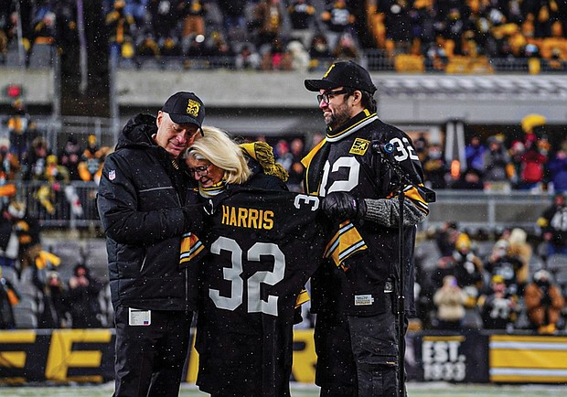 Franco Harris’ wife, Dana Dokmanovich, is consoled by Steelers owner Art Rooney II. At right is Franco and Dana’s son Dok.